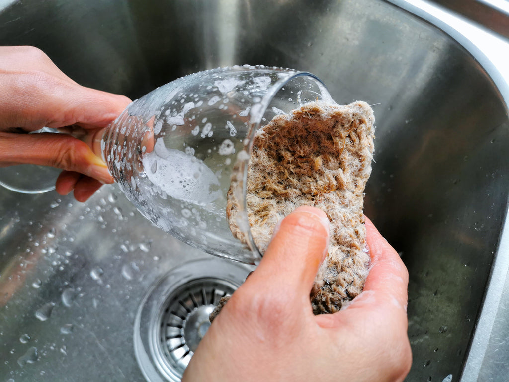Washing a wine glass with a jute scrubber