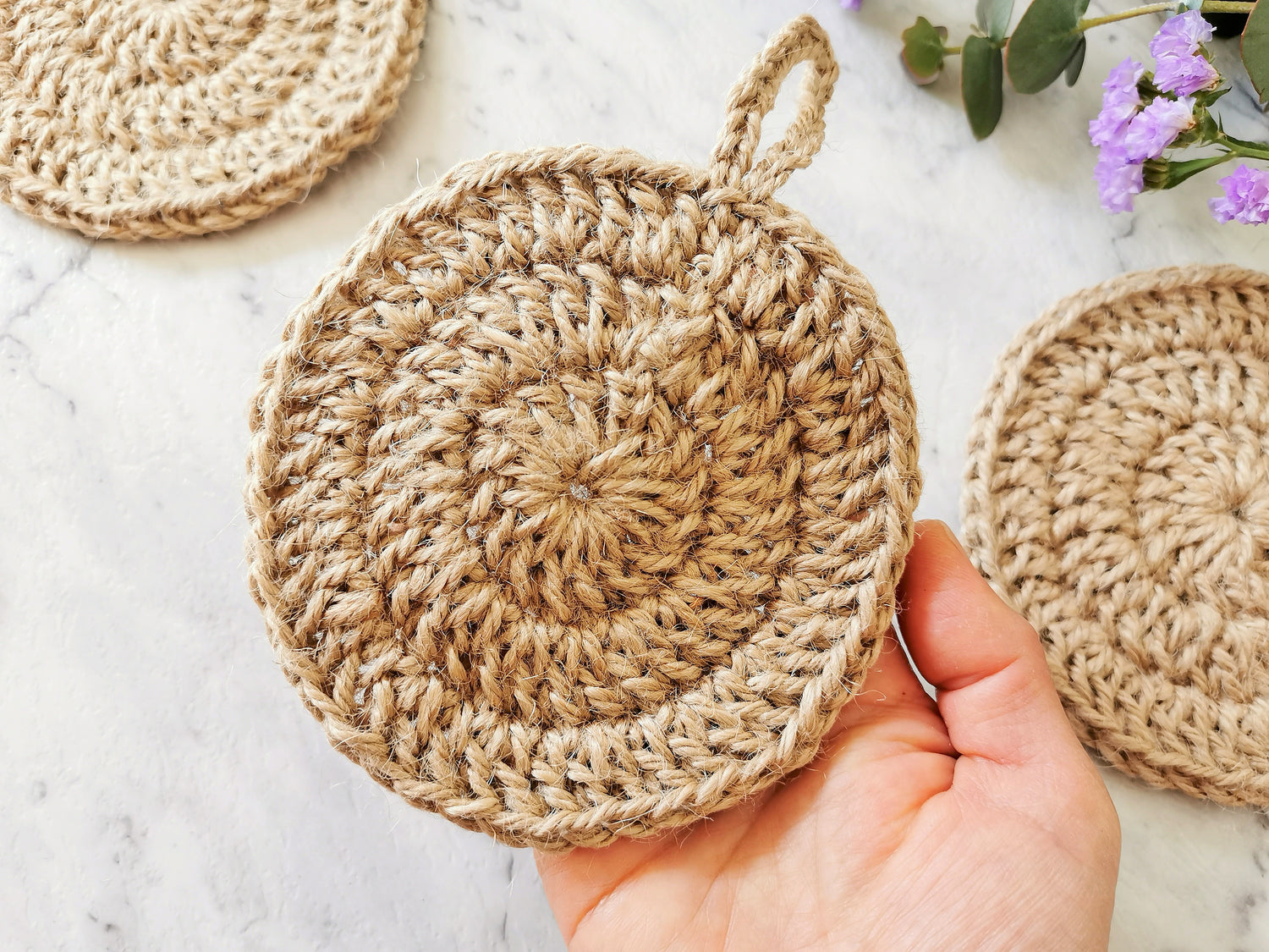 Holding a handmade dishwashing jute scrubbers