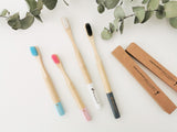 Bamboo toothbrushes charcoal, white, pink and blue in cardboard packaging boxes