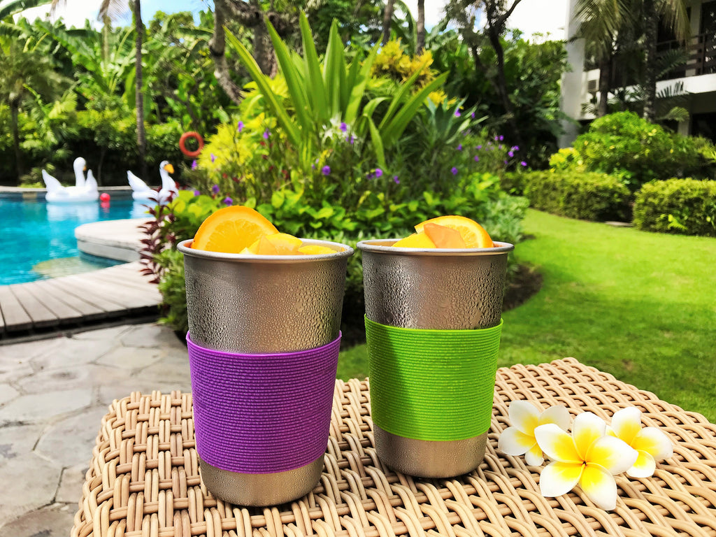 Fruit juice in stainless steel cups by the pool